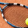 Which grand slam tennis tournament is played on red clay courts?